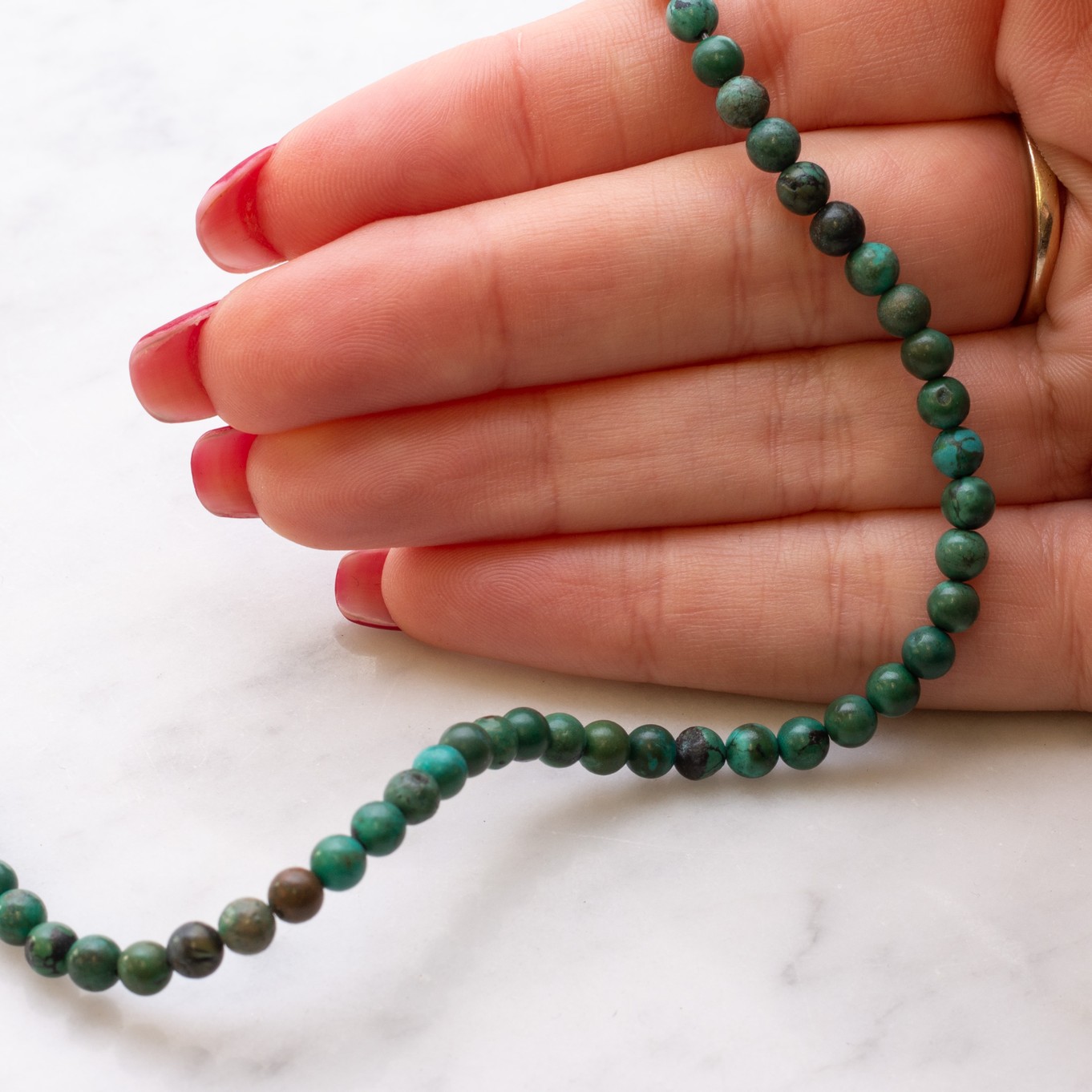 b337-turquoise-round-beads-hand.jpg